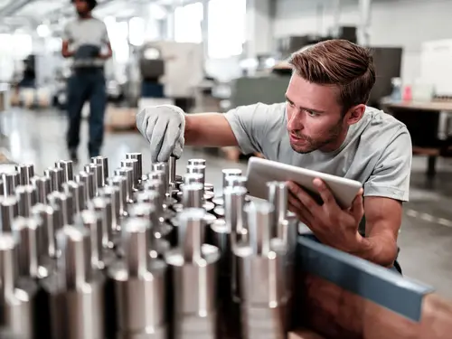 A worker checks metal parts